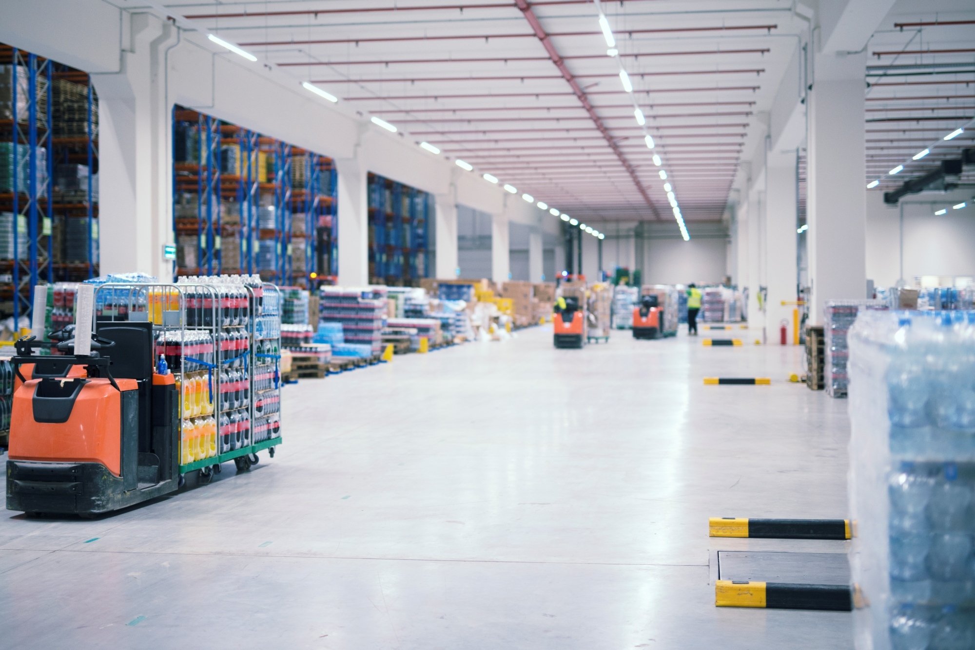 Almacén interior de nave industrial pequeña 2000 m2 con personas y carretillas elevadoras